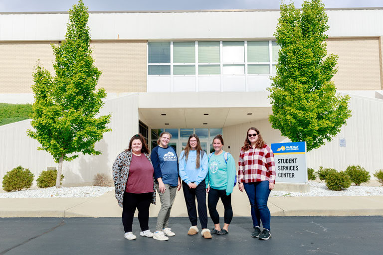group of students standing in front of the student services center
