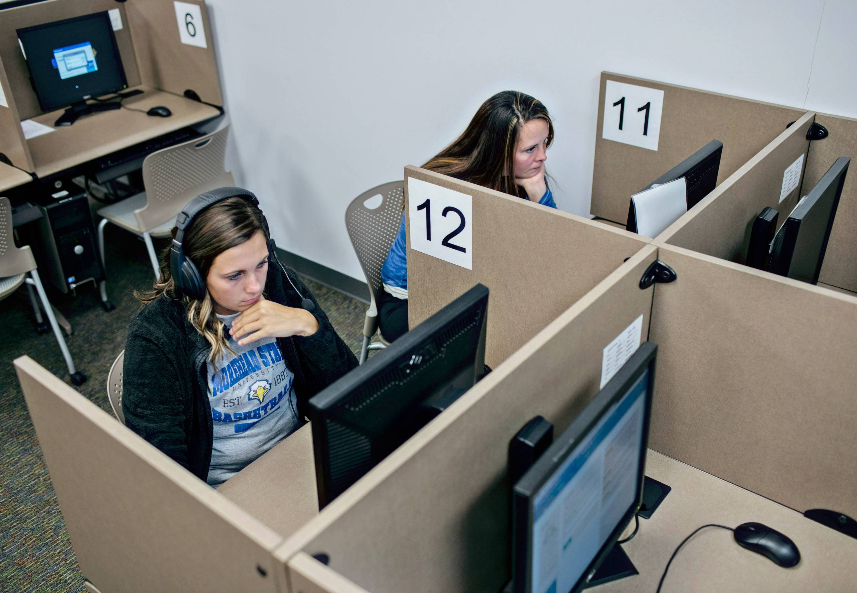 2 female students taking tests on the computer